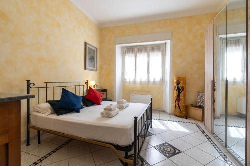 a bedroom with a bed with colorful pillows on it at Green Square Apartment 14 Min from Santa Croce with Hydromassage Tub in Florence