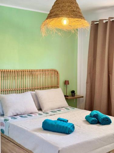 a bed with two blue pillows on top of it at Casa La Sofy in Costa de Antigua
