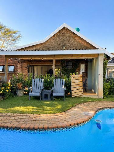 a house with two chairs next to a swimming pool at Bergview Apartments in Hilton