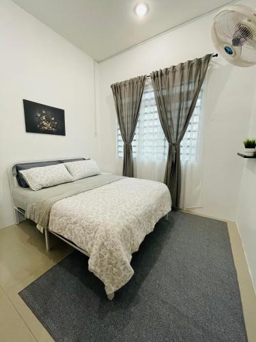 a white bedroom with a bed and a window at D Azlin Homestay in Kuala Kangsar