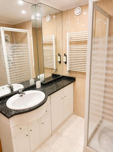 a bathroom with a sink and a shower at PORTO AGUDA BEACH ***** in Arcozelo