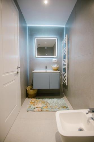 a bathroom with a white sink and a mirror at Triple Nest Korce in Korçë