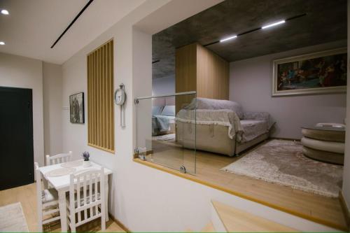a living room with a bed and a mirror at Triple Nest Korce in Korçë