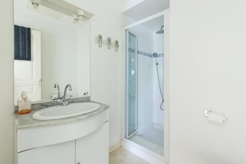 a white bathroom with a sink and a shower at Villa Léonidas - Conciergerieland in Léon