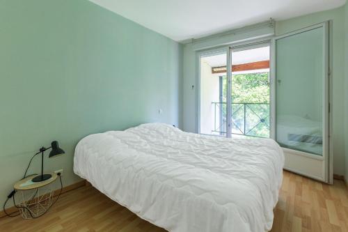 a bedroom with a large white bed and a window at Villa Léonidas - Conciergerieland in Léon