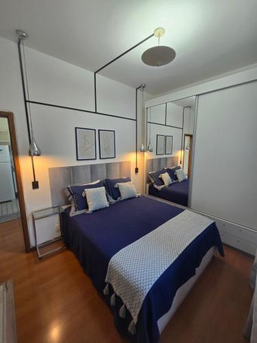 a bedroom with a large bed and a large mirror at Volpi Residence Savassi - VIP - Sinta-se em casa in Belo Horizonte