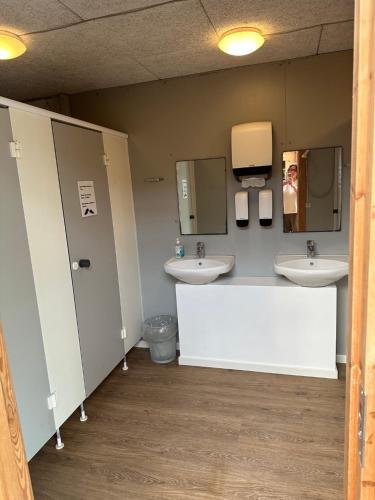 a bathroom with two sinks and two mirrors at Stege Camping in Stege