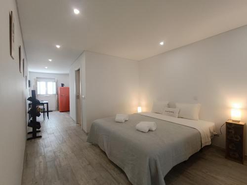 a bedroom with a large bed with two pillows on it at Tomarhousing - Secret Garden in Tomar