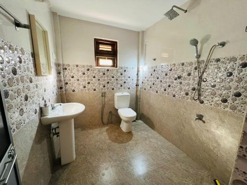 a bathroom with a toilet and a sink and a shower at Amantha Holiday Resort in Anuradhapura