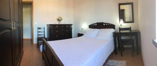 a bedroom with a bed and a desk and a table at PICO HOLIDAY RENTALS, Casa Do Avô Faidoca in Calheta de Nesquim