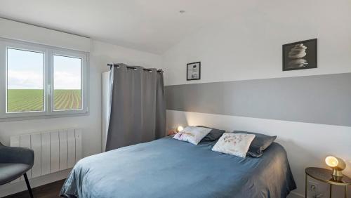 a bedroom with a blue bed and a window at Gîte Le Relais De Jehan in Saint-Malo des 3 Fontaines