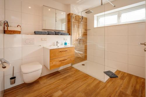 a bathroom with a shower and a toilet and a sink at Ferienwohnung Riethchaussee in Wingerode