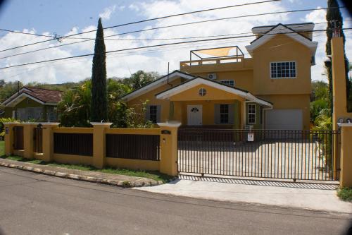 a yellow house with a black fence at The Vista Inn Studio #2 in Falmouth