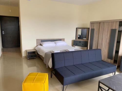 a bedroom with a bed and a bench in it at Chalet 103 - Zresidence - Faitroun in Al ‘Aqabah