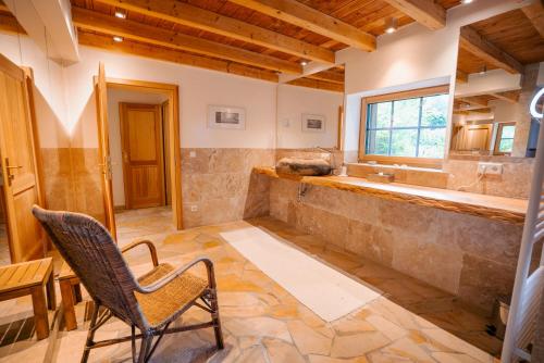 a bathroom with a tub and a chair in a room at NaturQuartier am Stadtrand von Nürnberg in Stein
