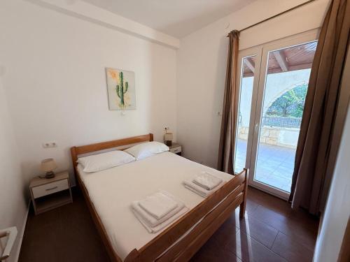 a bedroom with a bed with white sheets and a window at Apartments Tomislav in Vodice