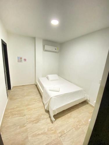 a bedroom with a white bed in a room at Hotel Nella Mar in Puerto Colombia