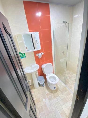 a bathroom with a toilet and a sink and a shower at Hotel Nella Mar in Puerto Colombia
