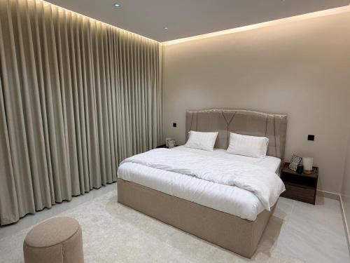 a bedroom with a large bed with white sheets at شقة مودرن غرفة وصالة in Buraydah