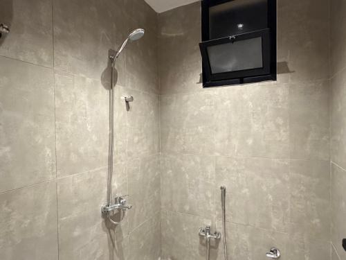 a bathroom with a shower with a television on the wall at شقة مودرن غرفة وصالة in Buraydah
