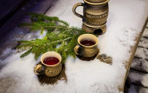 two cups of coffee on a table in the snow at Chaty Anety Domki Całoroczne in Solina