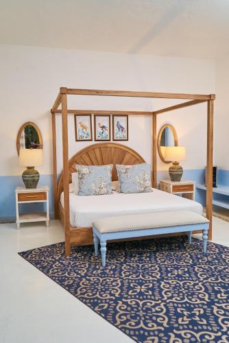 a bedroom with a canopy bed and a blue rug at El Bosque Hotel Boutique in Doradal