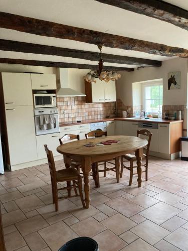 a kitchen with a wooden table and chairs in it at Sci Licorne d Or in Saint-Méloir-des-Ondes