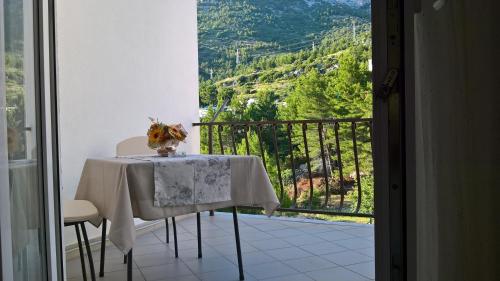 a table and chairs with a view of a mountain at Apartment & Rooms Marigold in Baška Voda