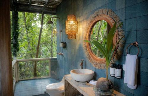 a bathroom with a sink and a mirror at El Bosque Hotel Boutique in Doradal