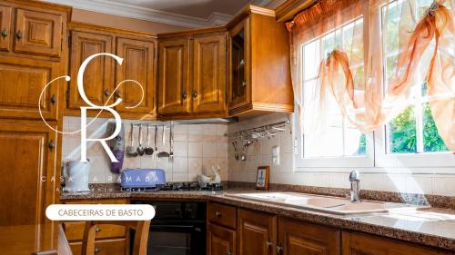 a kitchen with wooden cabinets and a sink and a window at Casa de Alvite in Alvito