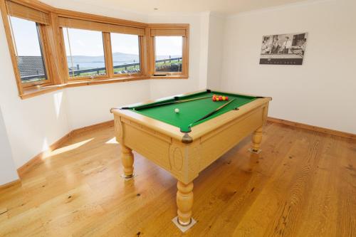 a green pool table in a room with windows at Quoys Self Catering, Shetland in Lerwick