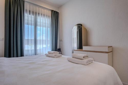 a bedroom with a large white bed with towels on it at Kaura Villas in Milas