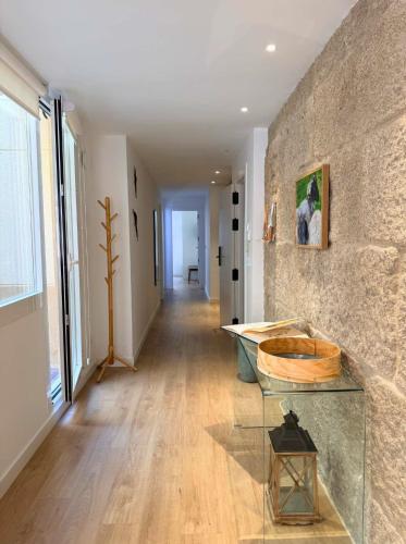 a hallway with a glass table and a stone wall at YourHouse O Rexo in Allariz