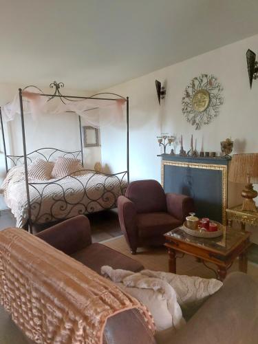 a bedroom with a bed and a chair and a table at Chambre d'Hôtes La Marlotte in Castello-di-Rostino
