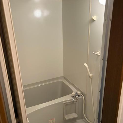a shower with a glass door in a bathroom at ゲストハウスヤドカリ in Nanao