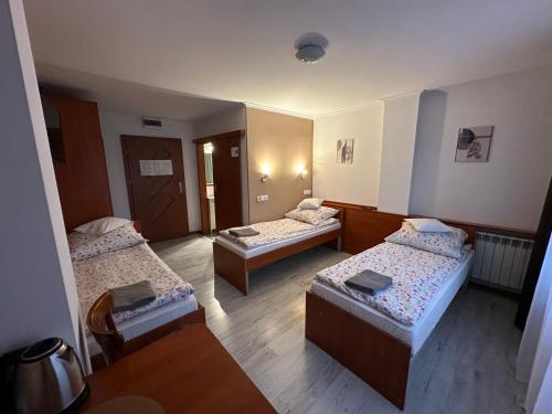 a room with three beds in a room at Bianco - pokoje noclegowe in Częstochowa