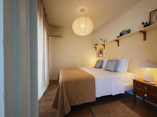 a bedroom with a white bed and a lamp at Sun Garden House Athens in Nea Makri