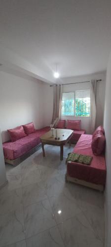a living room with two beds and a table at fenêtre de la mère in Al Hoceïma