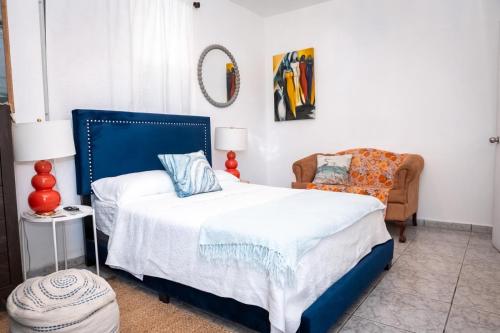 a bedroom with a blue bed and a chair at Cozy West Coast Studio in Cabo Rojo