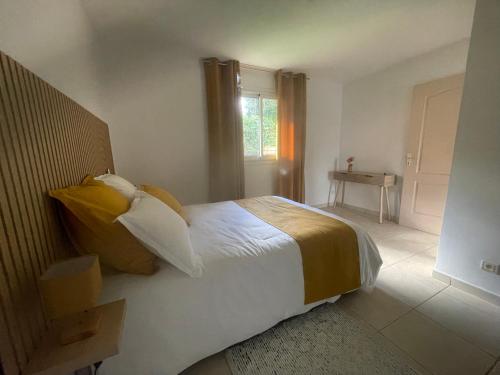 a bedroom with a bed with yellow and white pillows at La Villa Nature in La Plaine des Cafres