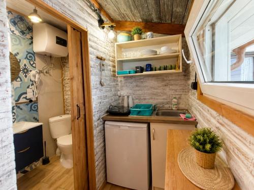 a tiny house with a sink and a toilet at Domki Promyk in Mrzeżyno