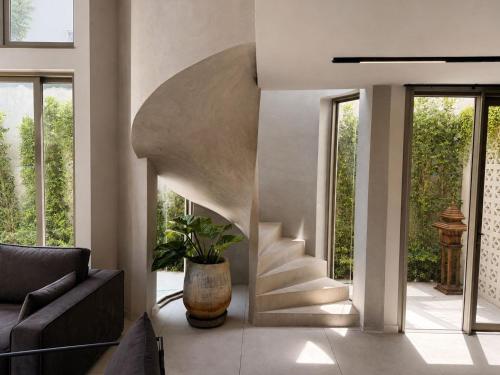 a living room with a spiral staircase in a house at Crown Chaloklum in Chaloklum