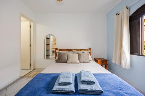 a bedroom with a bed with two towels on it at Casa a 500m da Praia do Sape in Ubatuba