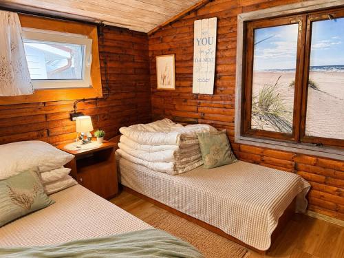 a room with two beds in a wooden cabin at Domki Promyk in Mrzeżyno