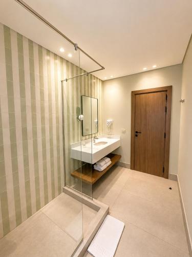 a bathroom with a sink and a glass shower at NOMA New Cairo in New cairo