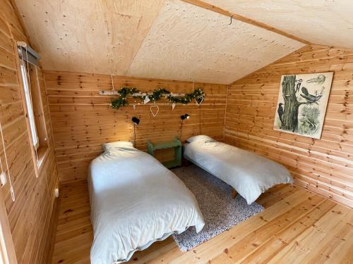 a room with two beds in a wooden cabin at Cabin in the Woods in Malung