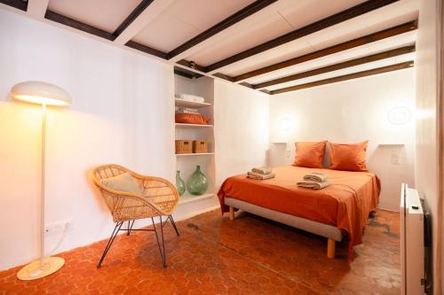 a bedroom with a bed and a chair in a room at Joli Cocon - Meublé de tourisme classé 2 étoiles - Terrasse - Parking in La Ciotat