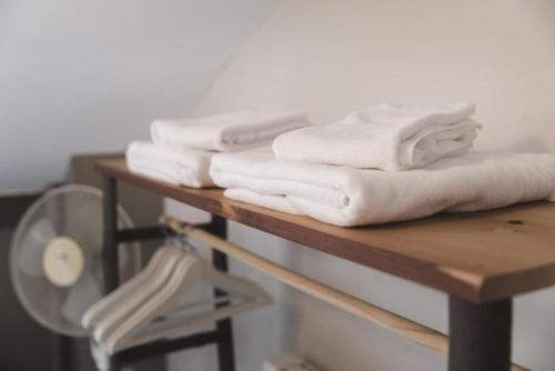 a pile of white towels sitting on a table at Le Cottage Bleu- In the Heart of Riquewihr by La Maison Bleue in Riquewihr