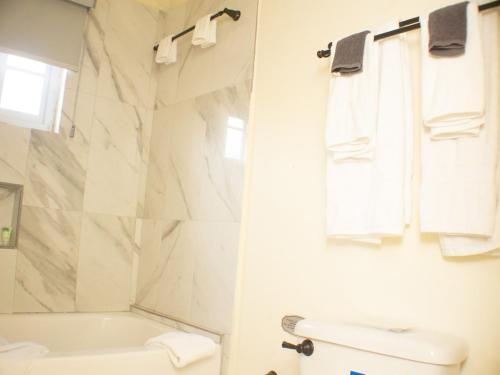 a white bathroom with a tub and a sink at The Vista Inn Studio #3 in Falmouth