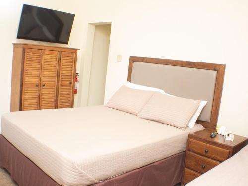 a bedroom with a bed with a tv on the wall at The Vista Inn Studio #3 in Falmouth